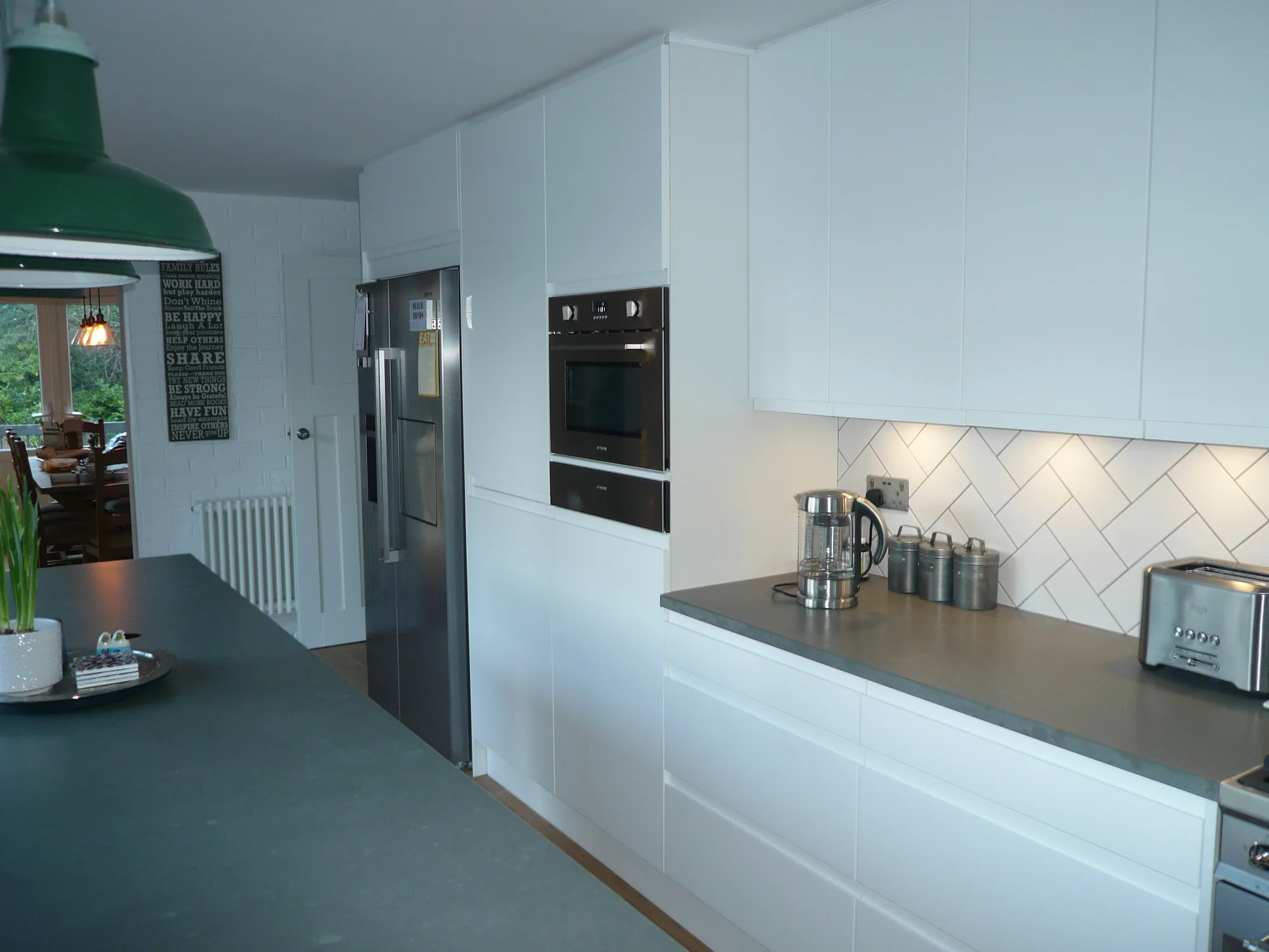 Fitted kitchen with a raised eye-level oven, low drawer storage and lit worktops