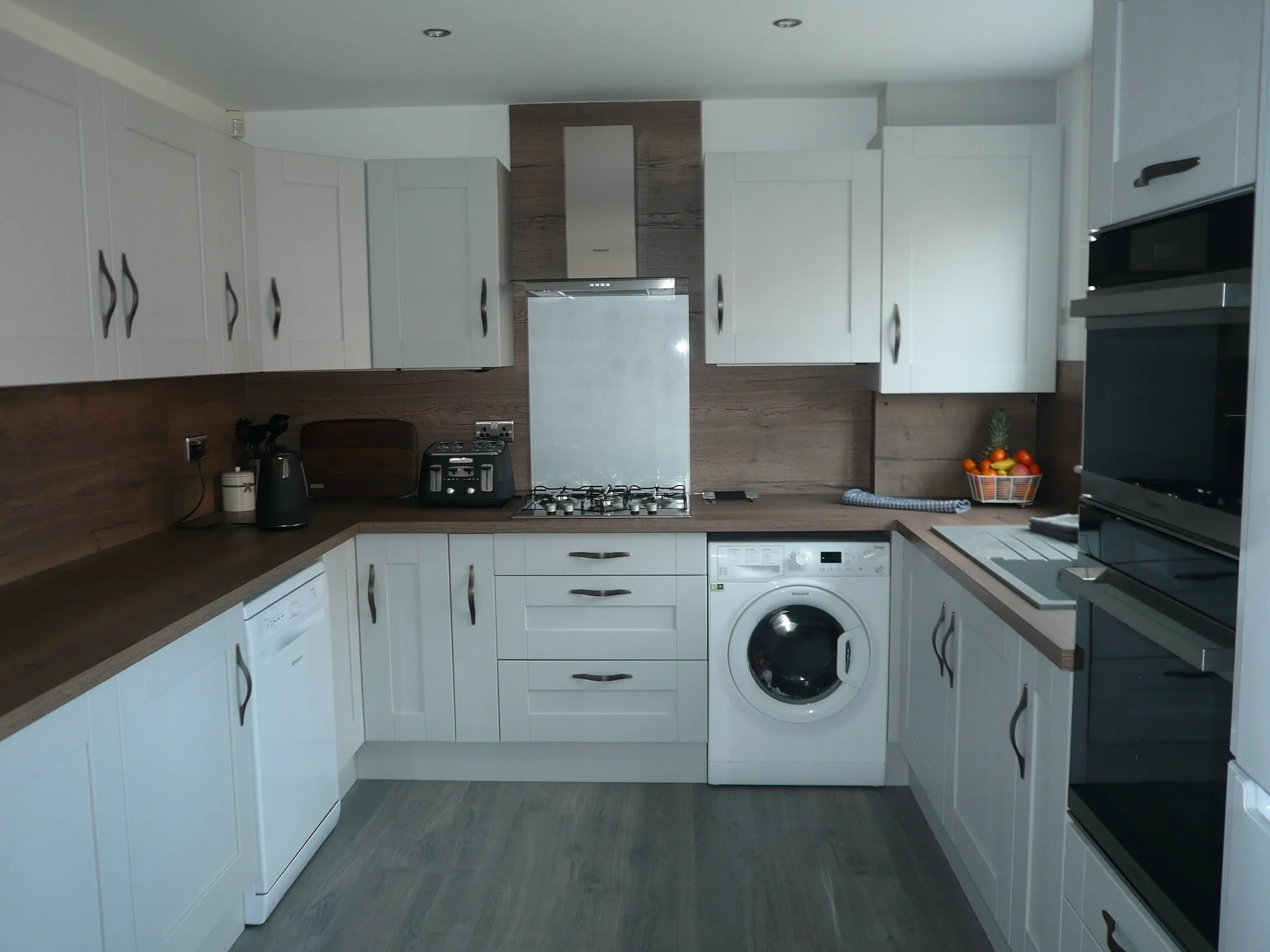 Finished U-shaped Cartmel shaker kitchen in light grey with dark oak-effect worktops, designed and fitted by Leith Kitchens in Glasgow